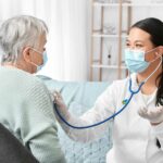Nurse listening to patient's heart during cardiac care