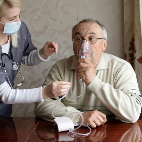Nurse Helping A Patient With A Nebulizer During Respiratory Care
