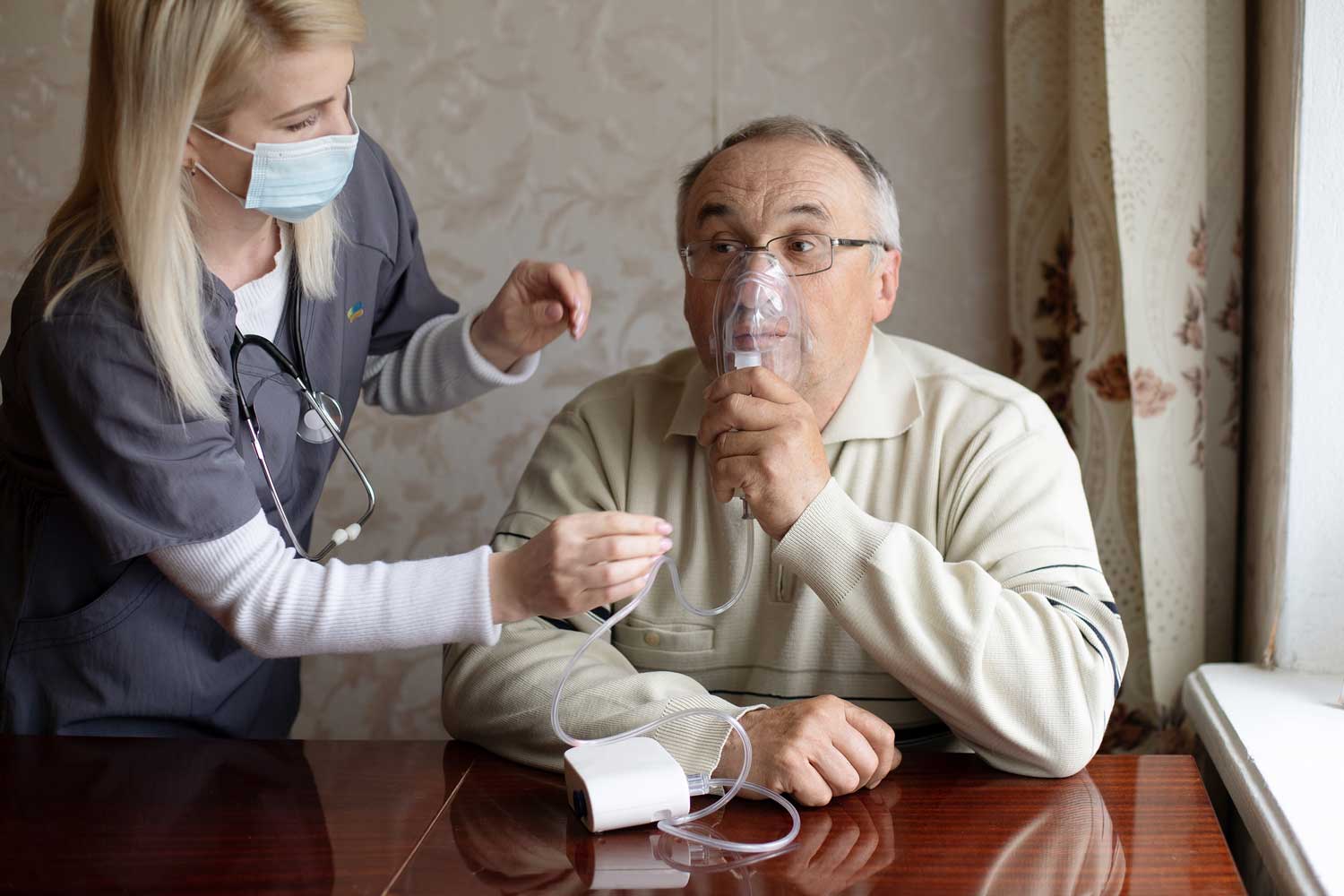 Nurse helping a patient with a nebulizer during respiratory care