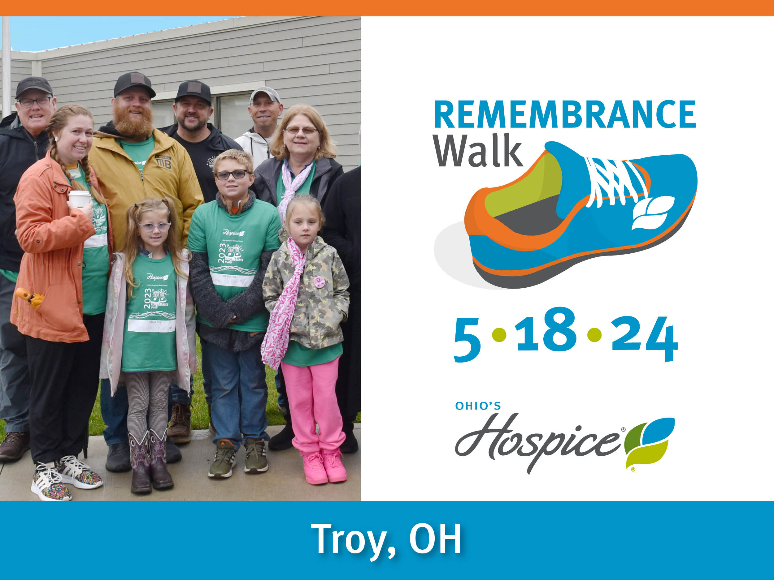 Remembrance Walk | 5/18/24 | Troy, OH Description: A group of smiling middle-aged people and children wearing fall coats stand grouped together for a posed photograph in front of a building. Most are wearing the 2023 Walk T-shirts.