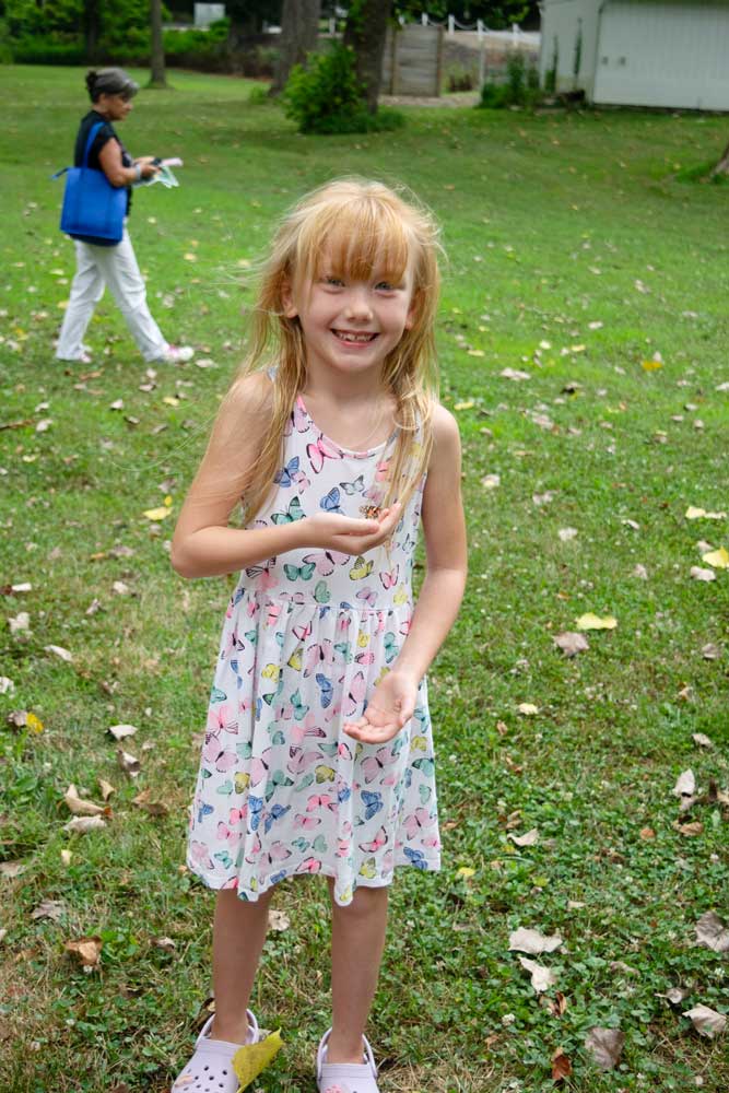 Little girl releasing a butterfly at the Newark Butterfly Release