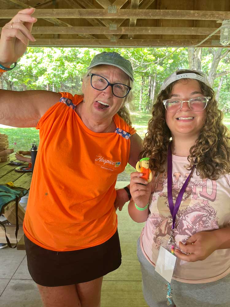 Camp Pathways North volunteer and child with clay project