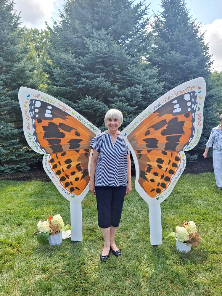 Ohio's Hospice Dayton Butterfly Release guest posing in front of wings